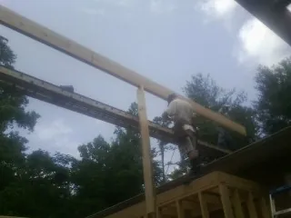 Carpenter setting a ridge beam over a new addition frame — Ice Dam Removal by Roofing Brothers in Yucaipa
