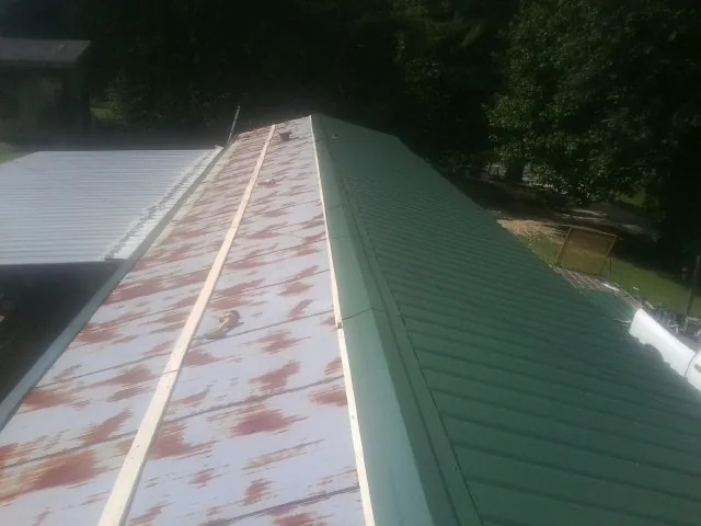 Old rusted panels beside newly installed green metal roofing — Wind Damage Roof Repair by Roofing Brothers in Yucaipa