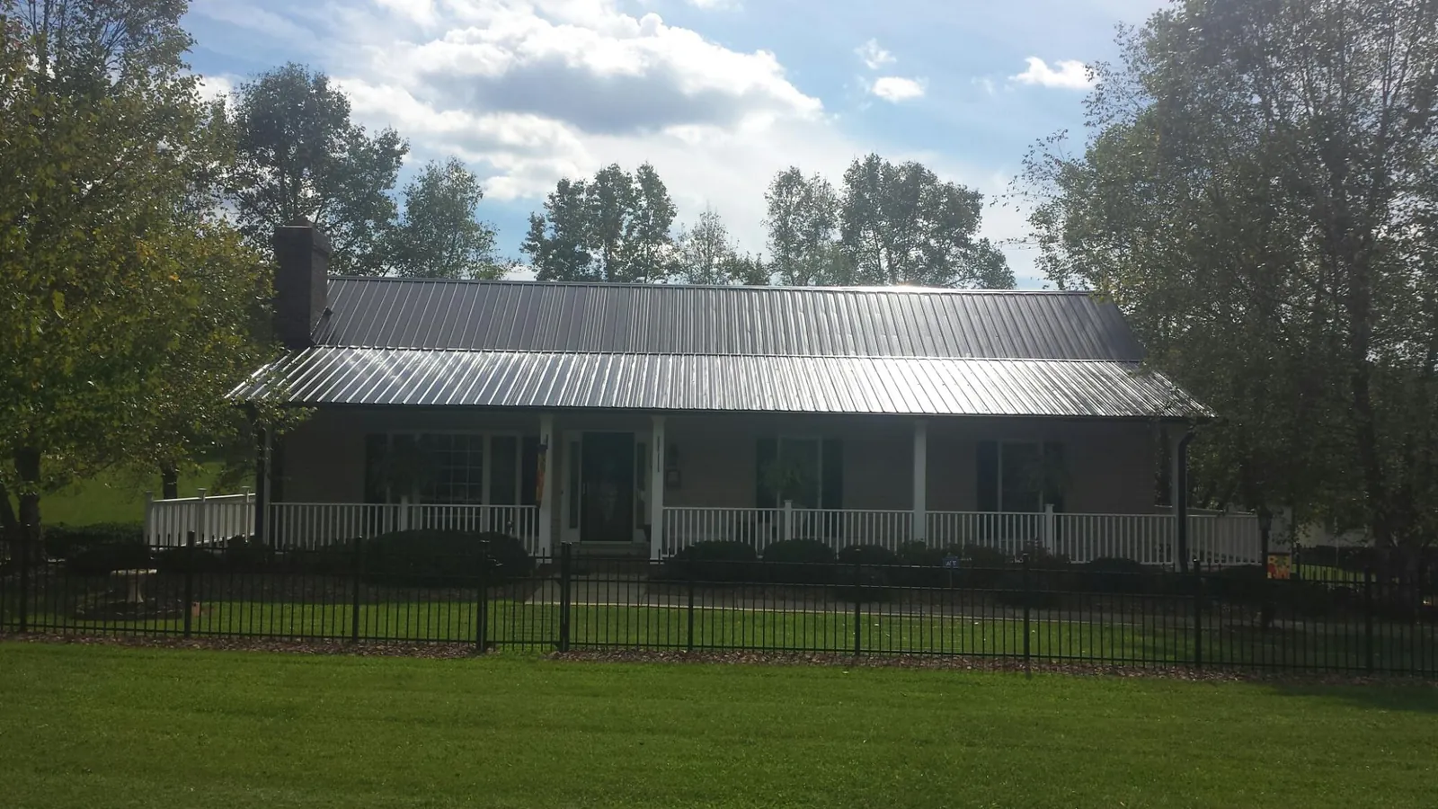 Gray metal roof on a brick ranch with a full width front porch — Gutter Guard Installation work by our crew in Yucaipa